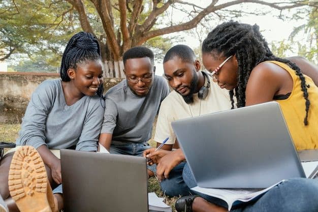 Four students studying with laptops outdoors